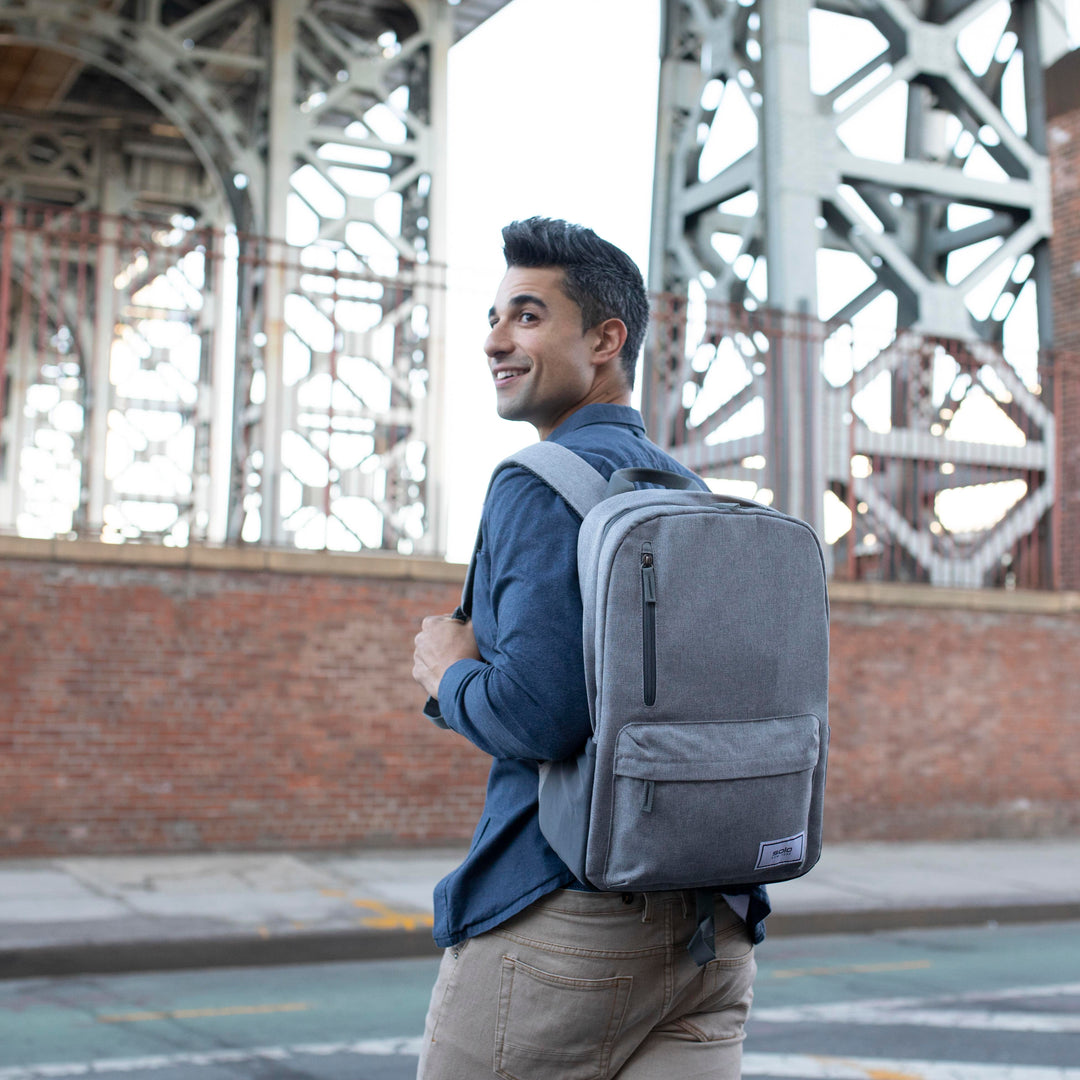 model walking down street wearing grey Solo Re:cover Backpack
