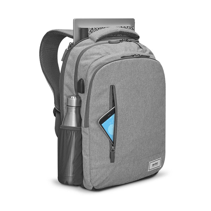Solo Re:define backpack in grey loaded with water bottle, tablet, notebook, and laptop