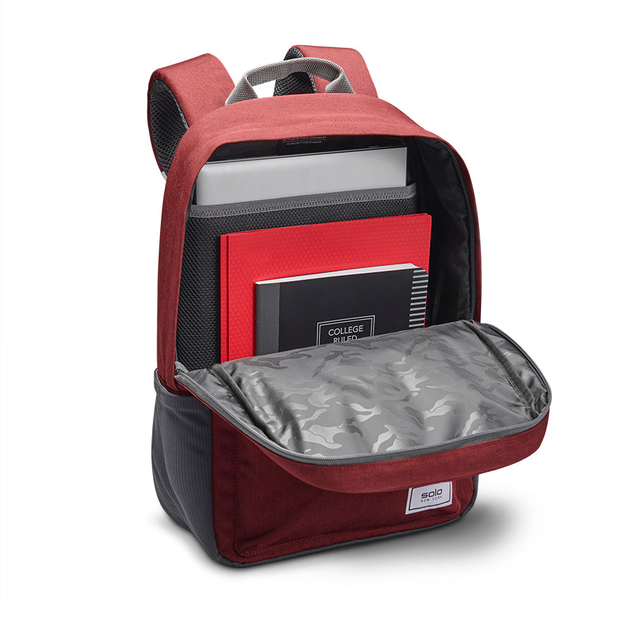 view of open interior pocket on Solo Re:cover Backpack in red loaded with notebook, folder, and computer