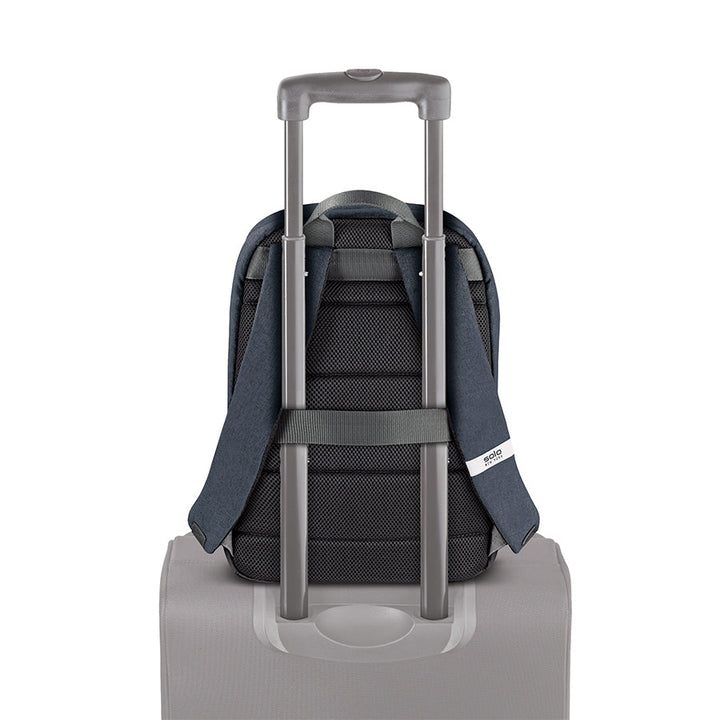 Solo Re:cover backpack in navy attached to suitcase handle