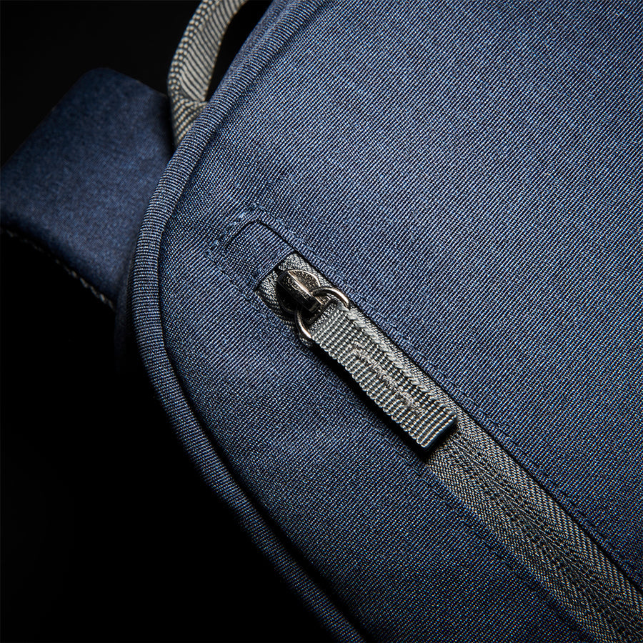 close up of zipper on front pocket of Solo Re:cover Backpack in navy